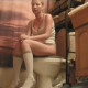 A blonde girl sits on a toilet and has some wet farts and some diarrhea. When finished, she gets up, cleans her has with her hands after wetting them in the sink, and towel dries her ass.